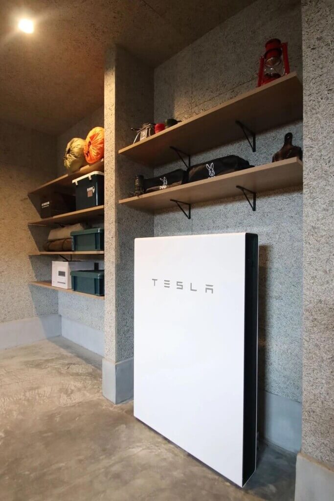 ジョイフルホームの常設型GX住宅モデルハウス-ガレージに映えるテスラ蓄電池
