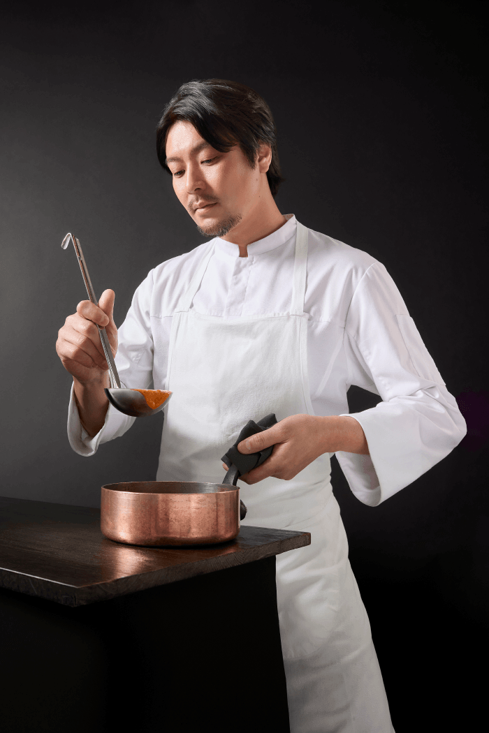 ベル食品の『下國伸シェフ監修 北海道ビスク風えびクリームカレー 180g』-カレーを調理する下國伸シェフ